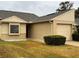 Tan brick ranch-style home with a two-car garage and landscaped lawn at 10842 Se 50Th Ave # 1, Belleview, FL 34420