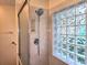 Updated shower with glass enclosure, built-in shelving, and a glass block window at 10975 Sw 69Th Cir, Ocala, FL 34476