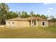 Single-story home with light brown exterior, a covered entryway, and a neatly landscaped yard at 12205 Sw 71St Lane Rd, Ocala, FL 34481