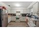 Kitchen with white cabinets, gas range and stainless steel fridge at 17411 Se 18Th St, Silver Springs, FL 34488