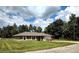 House exterior with a grassy yard and trees at 21 Maple Crse, Ocklawaha, FL 32179