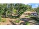 Large backyard with overgrown landscaping and mature trees at 3590 Sw 24Th Avenue Rd, Ocala, FL 34471