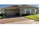 Tan house with a two-car garage and a brick driveway at 3642 Nw 55Th Cir, Ocala, FL 34482