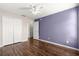 Bedroom with dark hardwood floors, purple accent wall and double doors at 6560 Sw 129Th St, Ocala, FL 34473