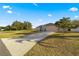 Single-story house with a long driveway and American flag at 6560 Sw 129Th St, Ocala, FL 34473