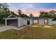 Newly built home with a modern design, black garage door, and landscaped yard at 176 Pine Crse, Ocala, FL 34472