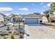 House exterior featuring a gray garage door and landscaped front yard at 3923 Manor Oaks Ct, Leesburg, FL 34748