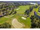 Aerial view of the golf course, with lush green fairways, sand traps, and surrounding trees at 9146 Sw 65Th Loop, Ocala, FL 34481