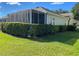 Screened-in patio area with lush green hedges for privacy at 9586 70Th Sw Loop, Ocala, FL 34481