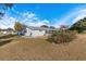 White single story home with large screened patio and red flowers at 10368 Se 178Th Pl, Summerfield, FL 34491