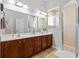 Bathroom with double vanity, wood cabinets, and a shower at 12157 Se 175Th Loop, Summerfield, FL 34491