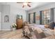 Main bedroom with wood furniture, ceiling fan and large windows at 12157 Se 175Th Loop, Summerfield, FL 34491