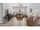 Bright living room with hardwood floors, comfortable seating, and large windows at 12157 Se 175Th Loop, Summerfield, FL 34491