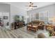 Spacious living room featuring hardwood floors, a cozy sofa, and a large TV at 12157 Se 175Th Loop, Summerfield, FL 34491