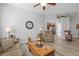 Relaxing living room with hardwood floors, comfortable seating, and views into kitchen at 12157 Se 175Th Loop, Summerfield, FL 34491