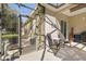Relaxing screened patio with seating for two and a view of the yard at 12157 Se 175Th Loop, Summerfield, FL 34491