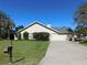 Tan house with attached garage and well-manicured lawn at 3282 Sw 9Th Ave, Ocala, FL 34471