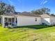 Home's backyard features a patio, screened enclosure, and grassy area at 725 Beldon Ct, The Villages, FL 32162