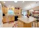 Kitchen with island, light wood cabinets, and stainless steel appliances at 725 Beldon Ct, The Villages, FL 32162