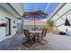 A covered patio with a dining table, chairs and umbrella at 8706 Sw 88Th Pl, Ocala, FL 34481