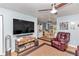 Living room with large TV, ceiling fan, and comfy seating at 9688 Se 122Nd Pl, Belleview, FL 34420