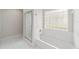 Clean bathroom with a shower, bathtub, and a block glass window at 11661 Sw 70Th Ct, Ocala, FL 34476