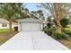 White house with gray accents, landscaping, and a two-car garage at 11661 Sw 70Th Ct, Ocala, FL 34476