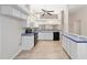 Bright kitchen with white cabinets, light blue countertops, and wood-look flooring at 11661 Sw 70Th Ct, Ocala, FL 34476