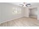 Living room with wood-look floors, ceiling fan, and access to another room at 11661 Sw 70Th Ct, Ocala, FL 34476