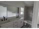 Modern bathroom with grey tile, double vanity, and walk-in shower at 13024 Ne 6 Pl, Silver Springs, FL 34488