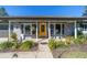 Inviting front porch with yellow door, bay window, and lush landscaping at 15330 Sw 59Th Ct, Ocala, FL 34473