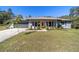 Gray house with yellow door, attached garage, and well-maintained landscaping at 15330 Sw 59Th Ct, Ocala, FL 34473