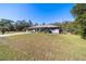 Gray house with yellow door and attached garage, sits on a large grassy lot at 15330 Sw 59Th Ct, Ocala, FL 34473