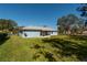 House's back exterior, showcasing a screened porch and yard at 24 Banyan Dr, Ocala, FL 34472