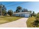 Front view of a light blue house with a yard and driveway at 24 Banyan Dr, Ocala, FL 34472