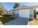 Side view of a light blue house with a white garage door at 24 Banyan Dr, Ocala, FL 34472