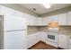 Galley-style kitchen with white cabinets and appliances at 24 Banyan Dr, Ocala, FL 34472