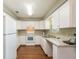 Efficient kitchen featuring white cabinets, laminate countertops, and appliances at 24 Banyan Dr, Ocala, FL 34472