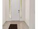Modern entryway with tiled floors, white door and sidelights, and a simple doormat at 6071 Sw 93Rd Loop, Ocala, FL 34476