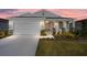 Attractive one-story house exterior with landscaping and a two-car garage at dusk at 6071 Sw 93Rd Loop, Ocala, FL 34476