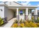 Covered front porch with stone columns, light-colored door, and lush landscaping at 6071 Sw 93Rd Loop, Ocala, FL 34476
