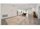 Open concept living room with neutral tones, large area rug, and view to kitchen at 6071 Sw 93Rd Loop, Ocala, FL 34476