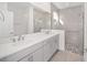 Elegant bathroom with double vanity, quartz countertops and a walk-in shower at 10330 Sw 99Th Ln, Ocala, FL 34481