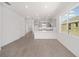 Spacious living area with wood-look tile flooring, kitchen and patio access at 10330 Sw 99Th Ln, Ocala, FL 34481