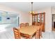 Dining room with wooden table, chairs, and china cabinet; view of kitchen at 11710 Sw 77Th Cir, Ocala, FL 34476