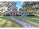 Ranch-style home with brick accents, mature trees, and a brick walkway at 1416 Se 17Th Ave, Ocala, FL 34471