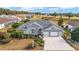 Single-story house with a large backyard, three-car garage, and a view of a golf course community at 2699 Nw 58Th Terrace, Ocala, FL 34482