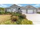 Single-story home with a three-car garage, mature landscaping, and a welcoming front entrance at 2699 Nw 58Th Terrace, Ocala, FL 34482
