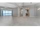 Open living room with tile floors, view of the lake, and kitchen access at 3456 Conservation Trl, The Villages, FL 32163