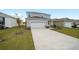Two-story house with gray siding, stone accents, and a large driveway at 5886 Sw 78Th Avenue Rd, Ocala, FL 34474